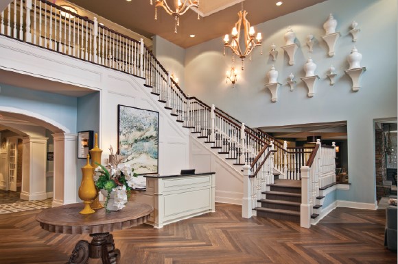Elegant lobby of a senior living community with a grand staircase and stylish decor.