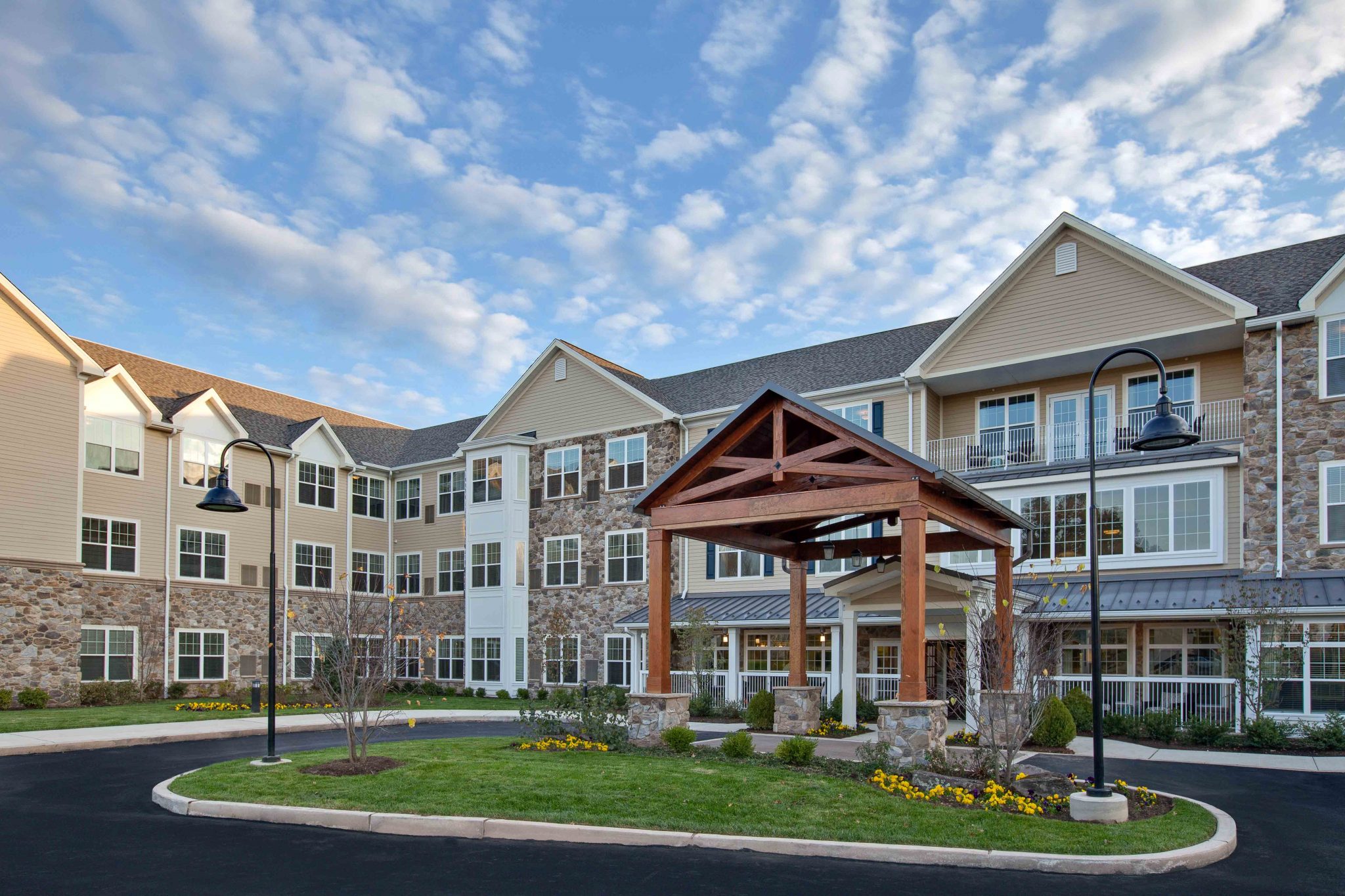 Exterior view of a multi-story senior living community building with landscaped front area.